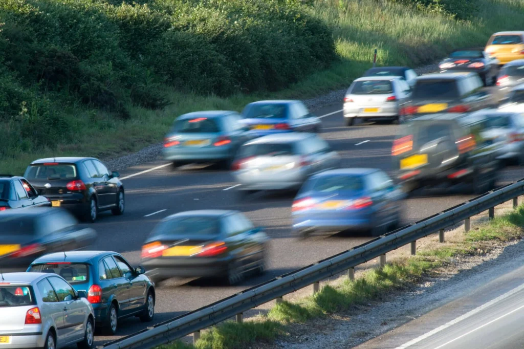 autos circulando en autopista con tráfico intenso y próximas salidas