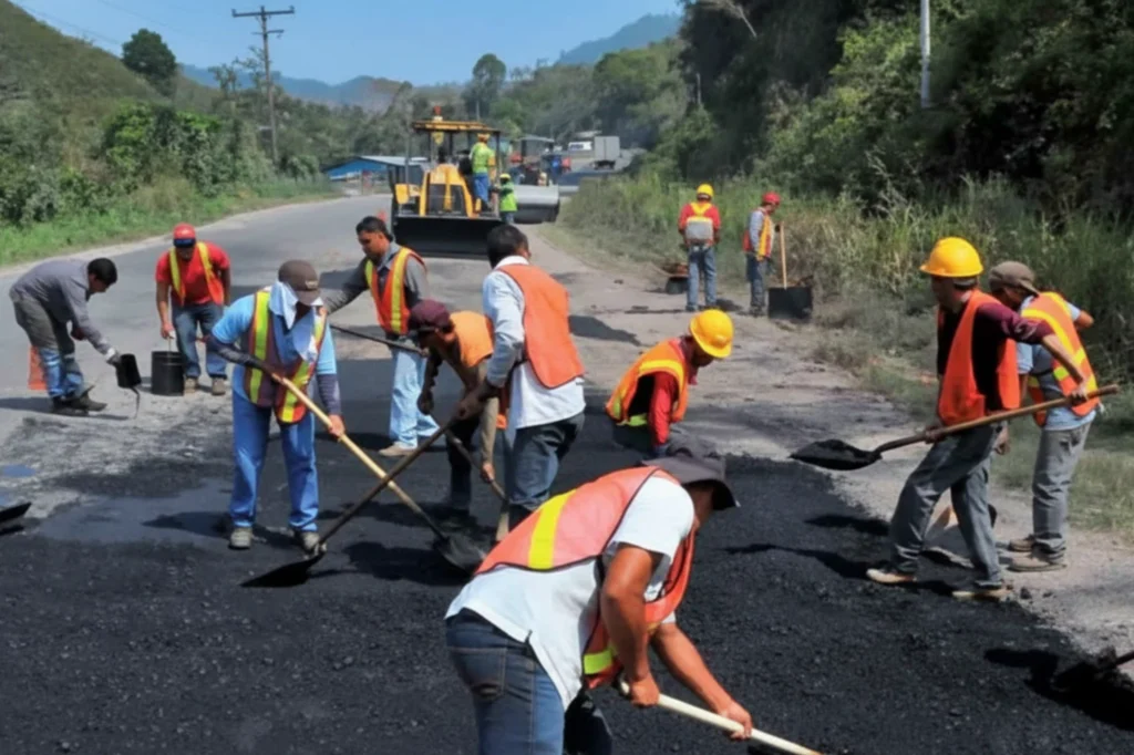 Camineros trabajando en mantenimiento de carretera durante el Día del Caminero, mostrando labores de conservación vial y pavimentación en México