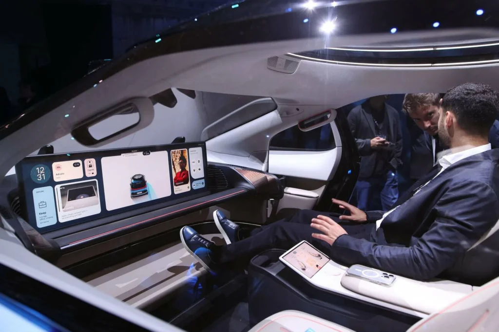 Interior de un robotaxi con pantallas digitales y pasajeros viajando sin conductor.
