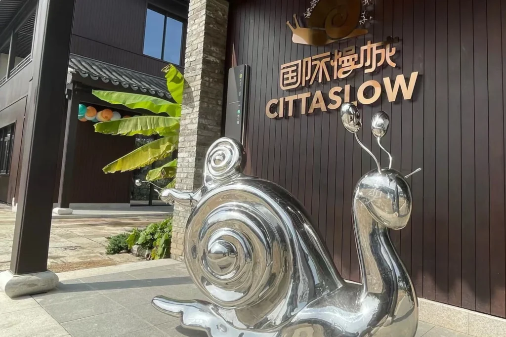 Escultura del caracol Cittaslow en un espacio público de China, símbolo del movimiento internacional de ciudades Cittaslow.