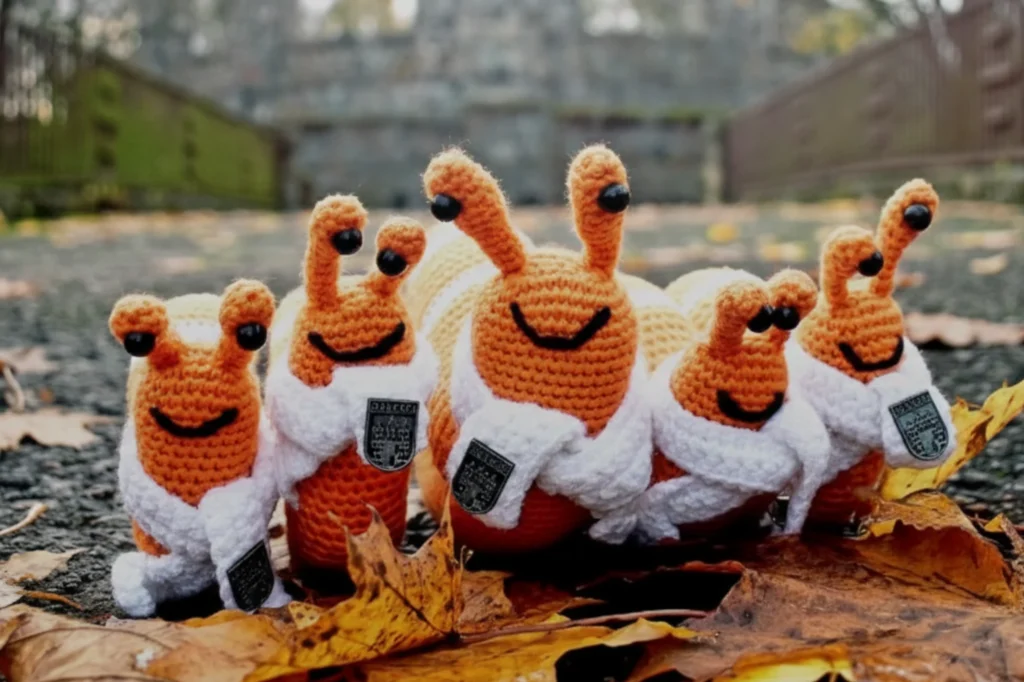 Figuras de caracoles tejidos que representan la identidad visual de una slow city orientada al bienestar cotidiano.