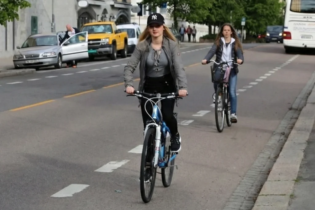 Ciclistas desplazándose en una vía urbana que refleja el enfoque Copenhagenize para promover trayectos seguros y eficientes en la ciudad.
